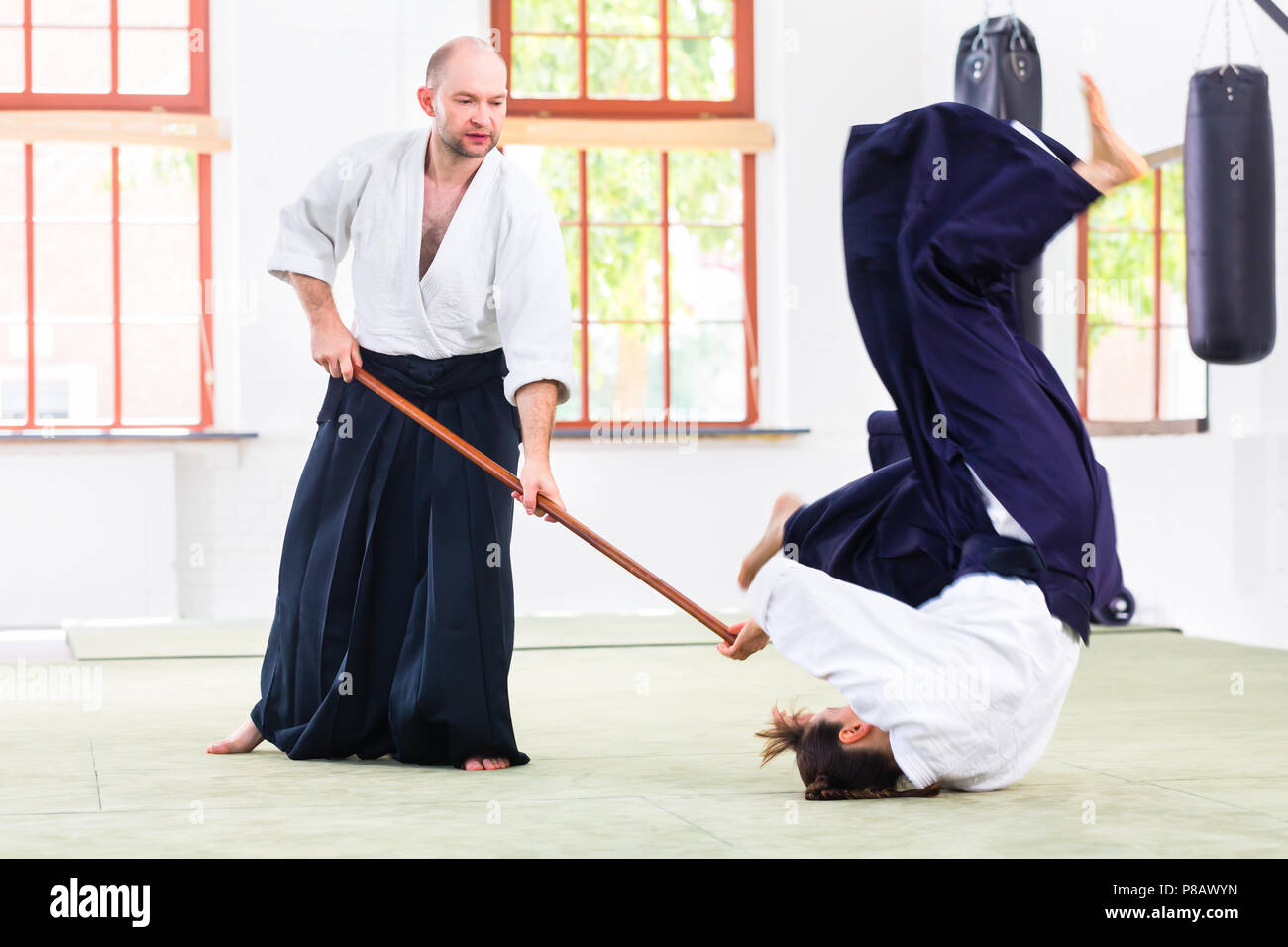 Man and woman having Aikido stick fight Stock Photo