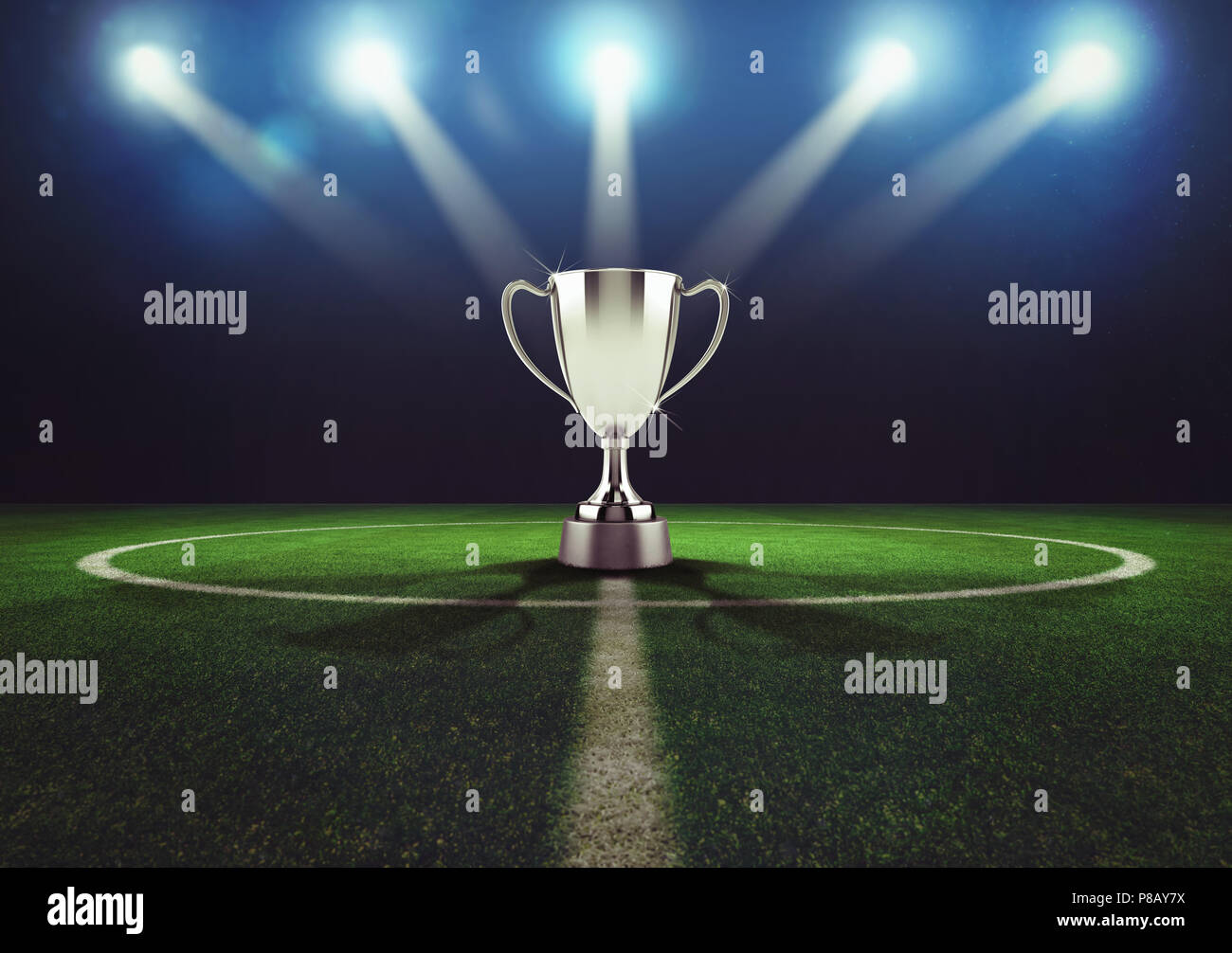 Silver winner's cup in the middle of a soccer field Stock Photo