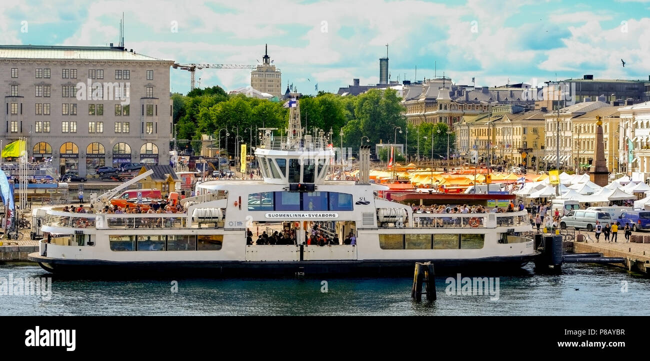 Helsinki, Finland 7.7.2018 Suomenlinna ferry in the port of the sea. The boat is full of passengers. Market square on the right side. Stock Photo
