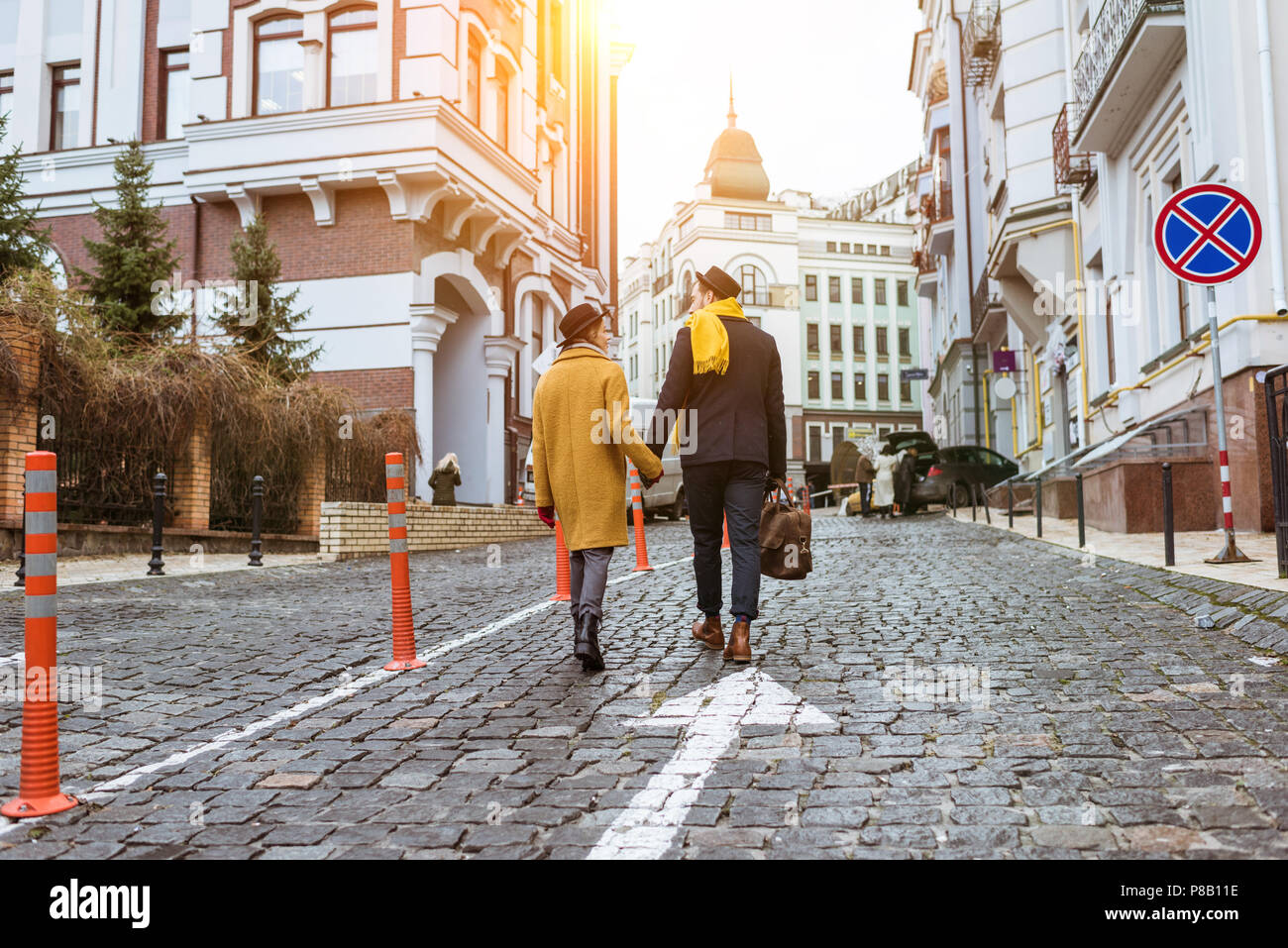 back view of couple holding hands and walking on street Stock Photo - Alamy