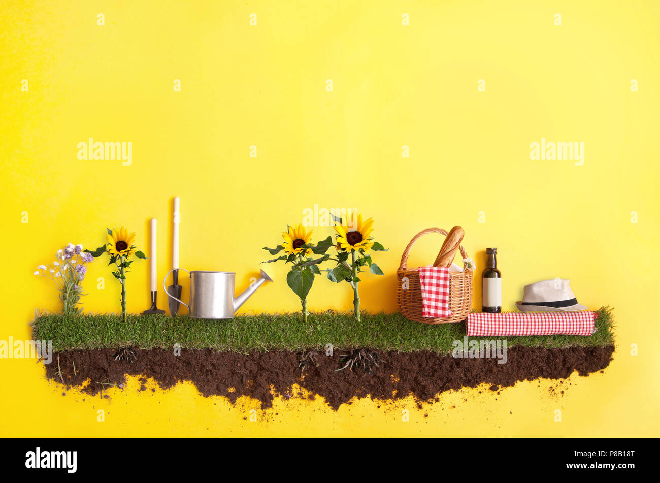 Summer picnic basket on grass patch with sunflowers Stock Photo
