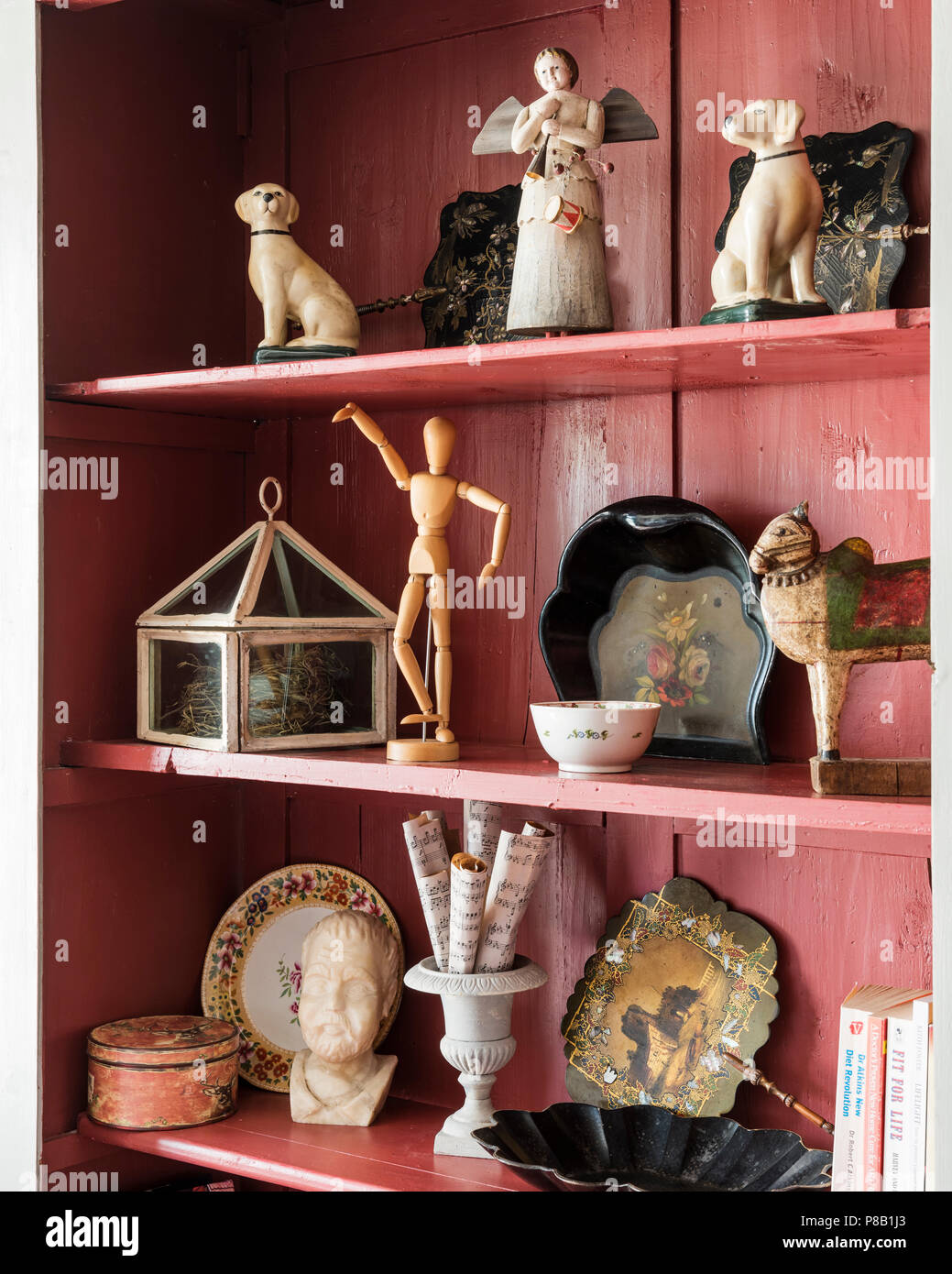 Ornaments and figurines on pink painted shelves Stock Photo