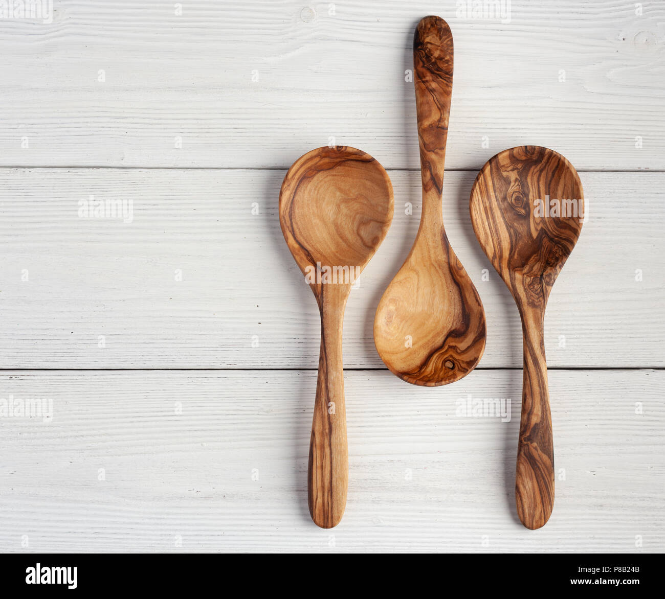 Three kitchen utensils against a white background - fish slice, potato  masher and wooden spoon Stock Photo - Alamy