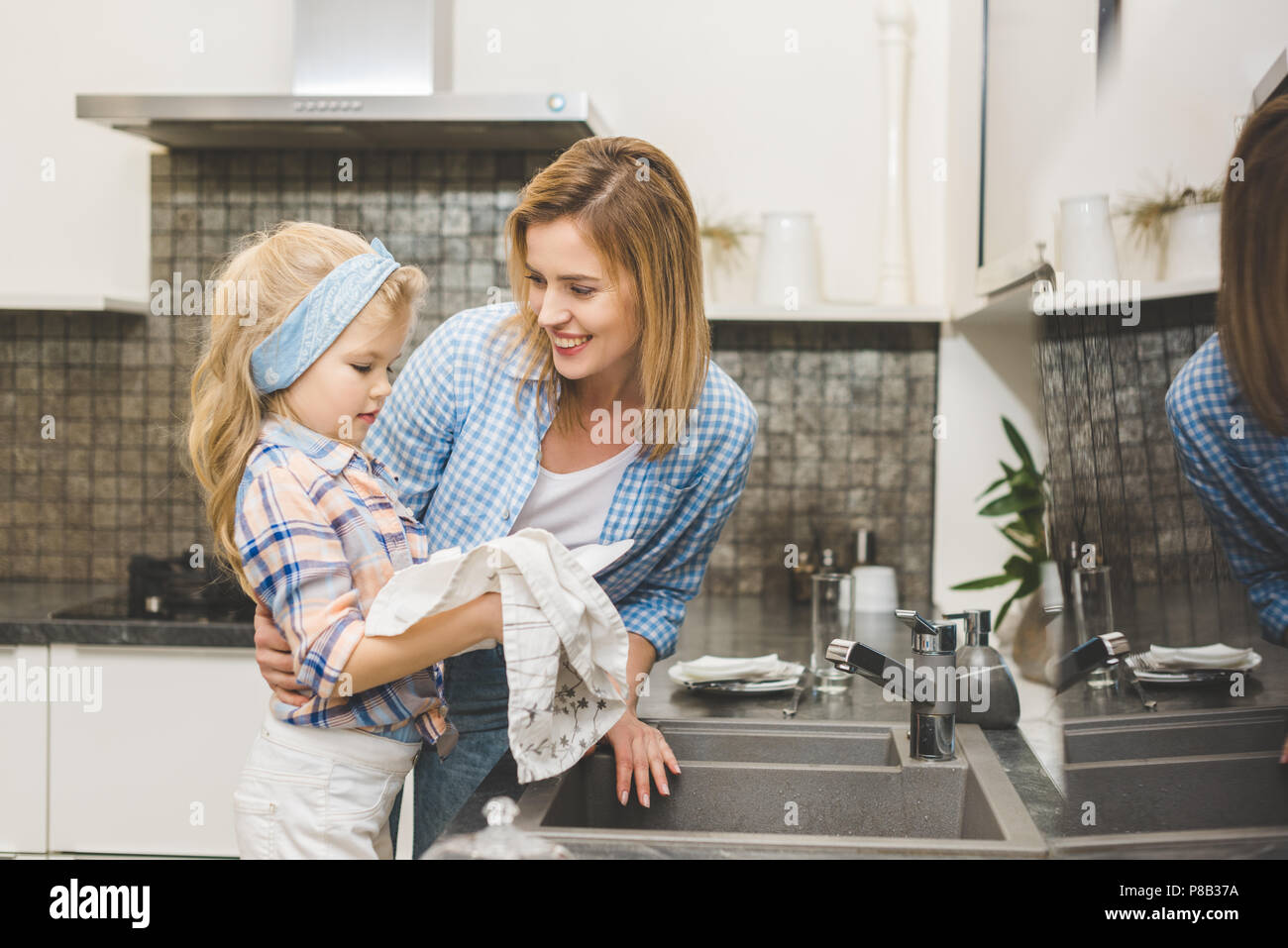 Дочка моет посуду. Мама с дочкой моют посуду. Девочка помогает маме мыть посуду. Помогать маме по дому. Фотосессия мама и дочка на кухне.