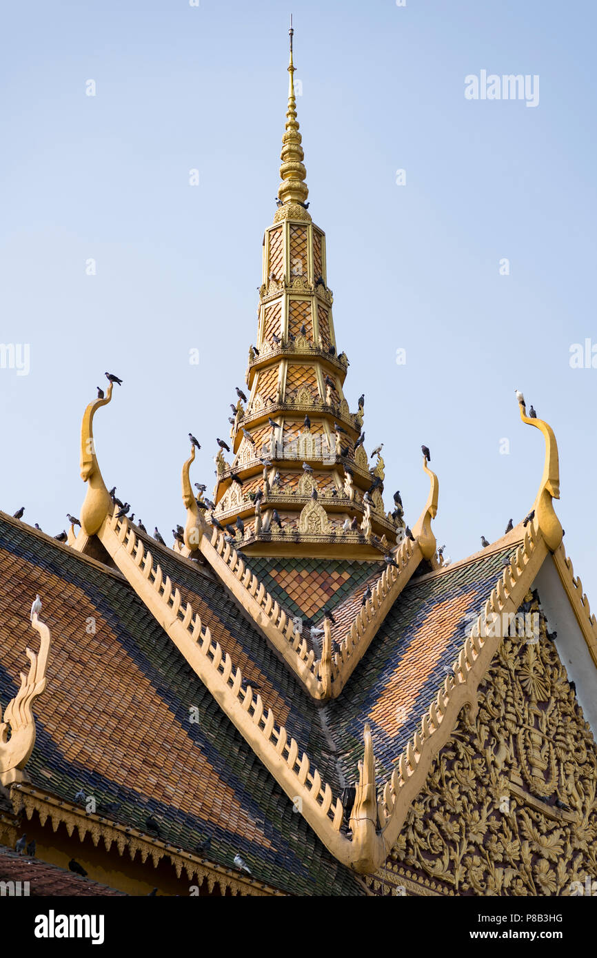 A spire of a bulding at the Royal Palace of Phnom Penh, Cambodia with many Pigeons invading the roof Stock Photo