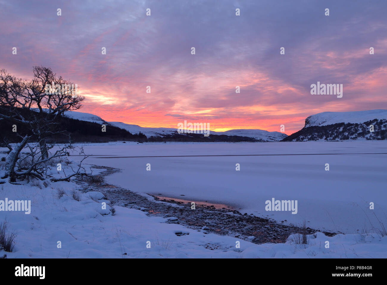Loch Brora in the Scottish Highlands completely frozen over with a covering of snow. Stock Photo