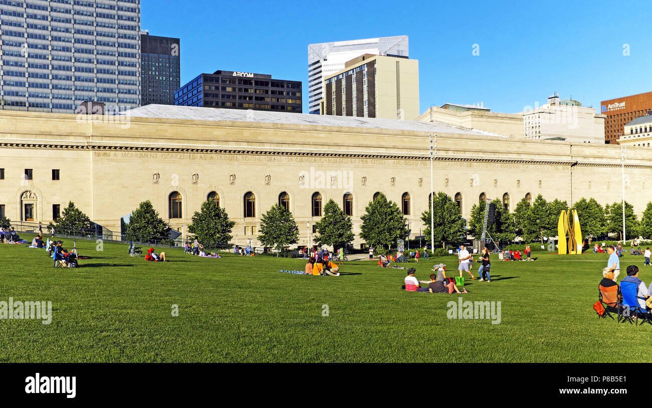 People relax in the Mall B grass area next to Cleveland Public Hall in downtown Cleveland, Ohio, USA on a summer evening. Stock Photo