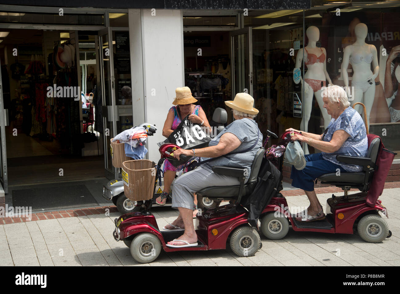 Bognor Regis, Sussex. Three older women shopping on their mobility scooters. Stock Photo