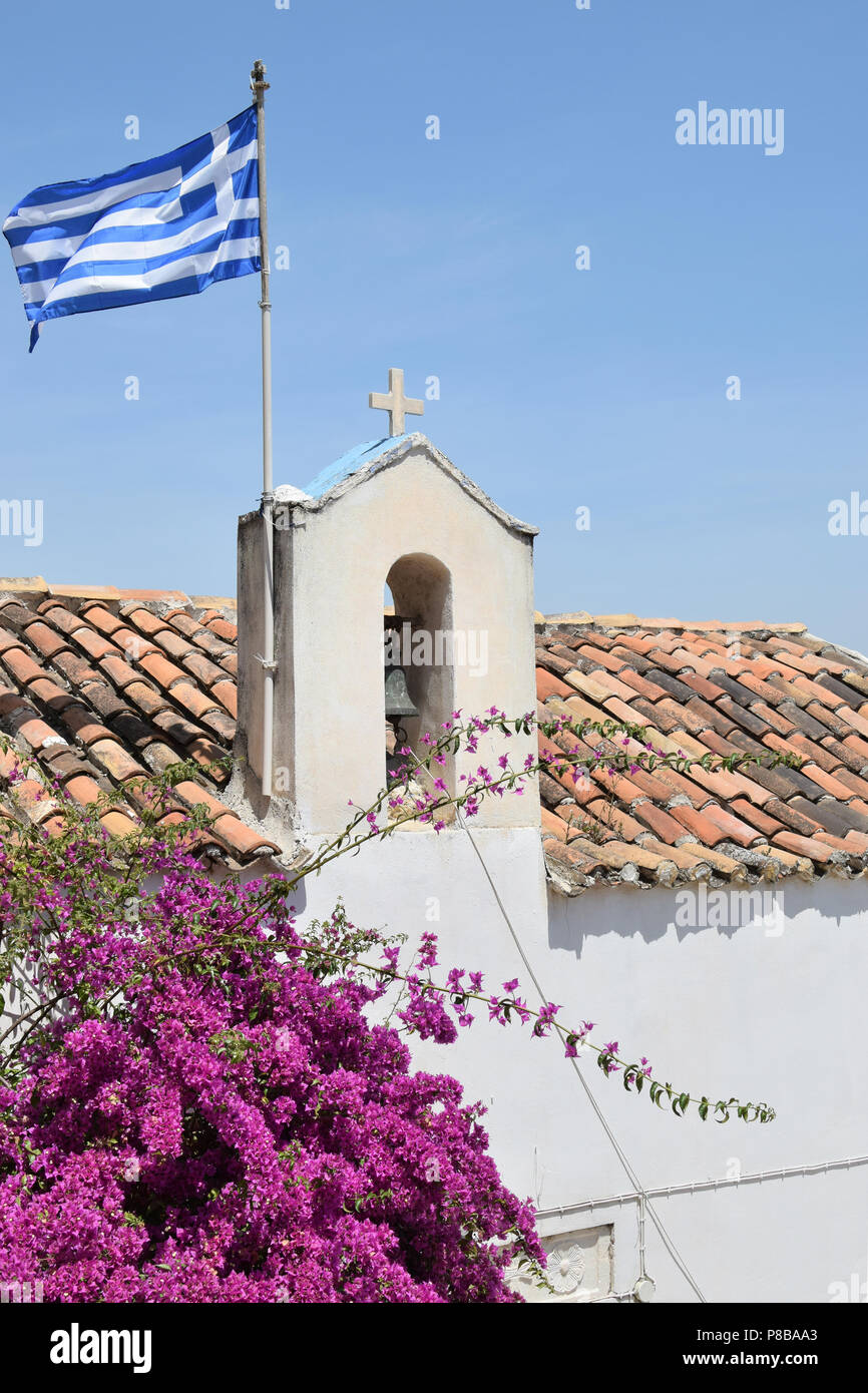 Church steeple with flag and bougainvillea flowers in downtown Athens, Greece. Stock Photo