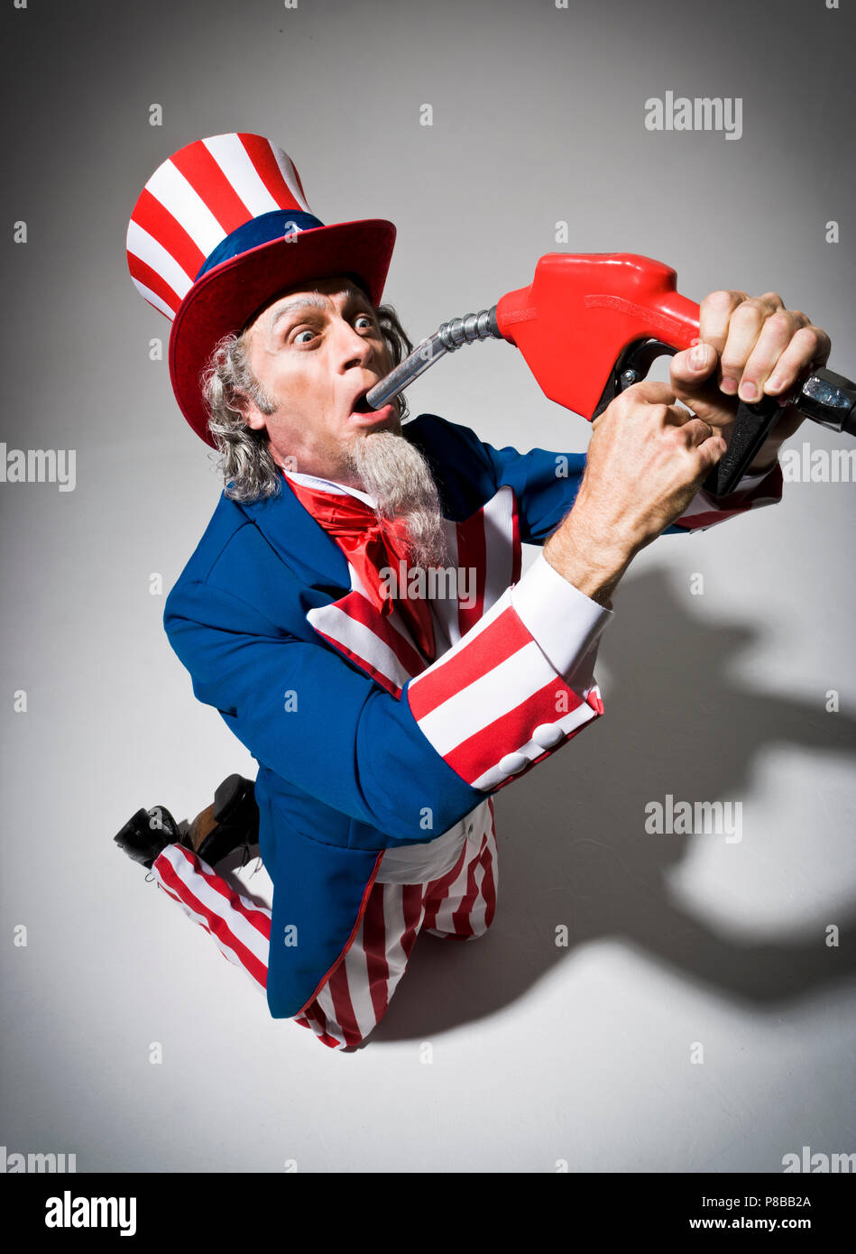 Uncle Sam kneeling with a gas pump nozzle held in front of his mouth as