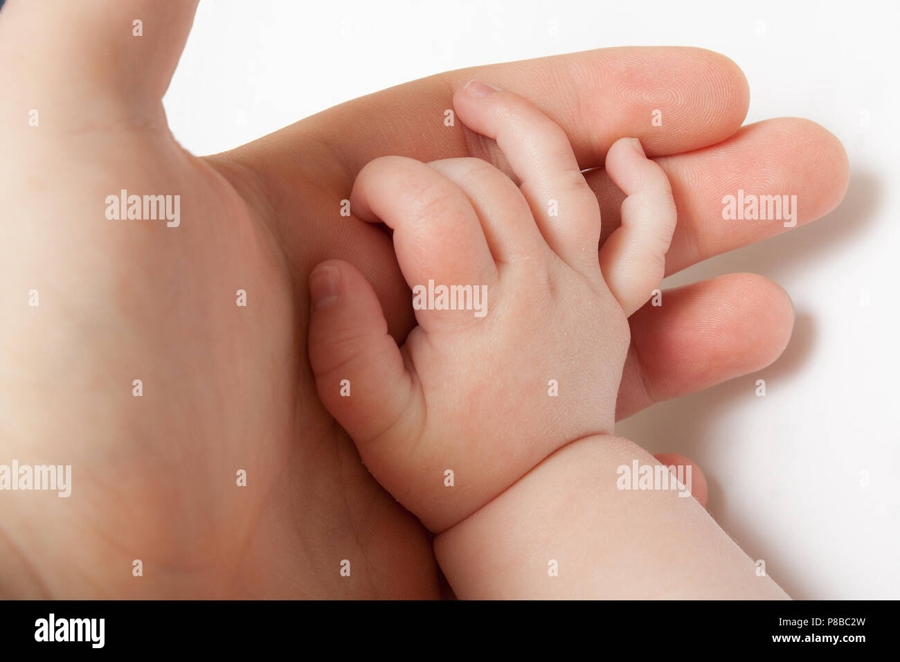 A child has their baby hand open and in their parents hand Stock Photo ...