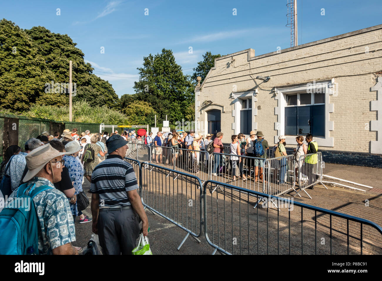 Queue of people at Hampton Court rail station waiting for a delayed train after a cancelled train, having been to Hampton Court Palace flower show. Stock Photo