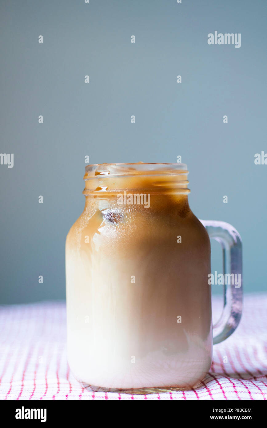 https://c8.alamy.com/comp/P8BCBM/iced-coffee-in-a-mason-jar-mug-with-a-straw-on-table-cloth-on-gray-background-summer-drink-beverage-concept-P8BCBM.jpg