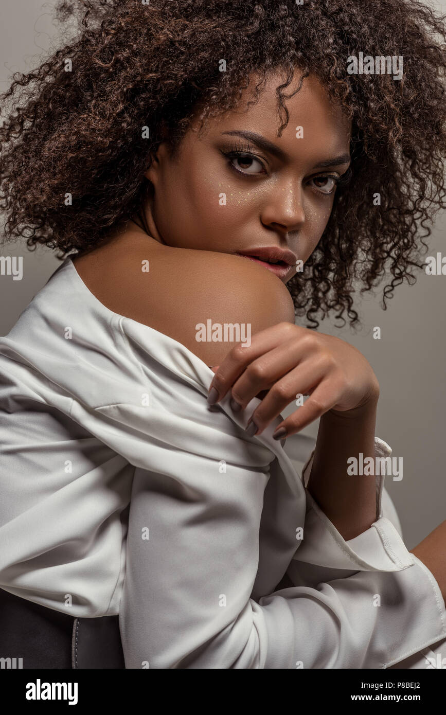 Young sensual african american woman in white shirt looking at camera ...