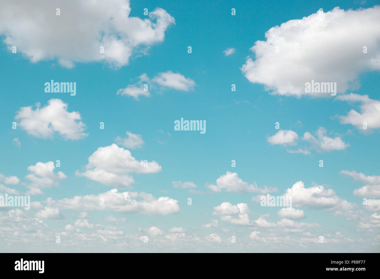 Background of white fluffy clouds and blue sky with vintage filter. Gradient celestial azure cloudscape. Good weather. Stock Photo