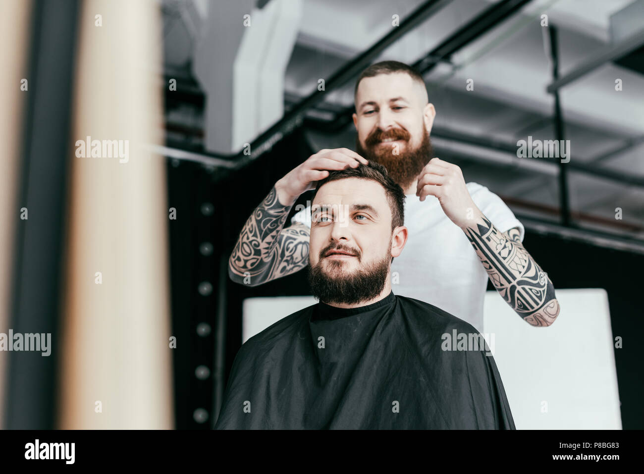 barber styling customer hair at barbershop Stock Photo