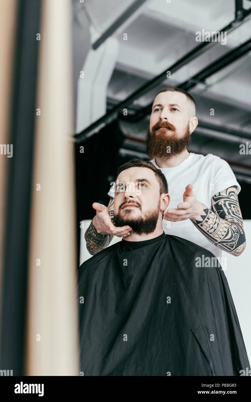 barber styling customer beard at barbershop Stock Photo