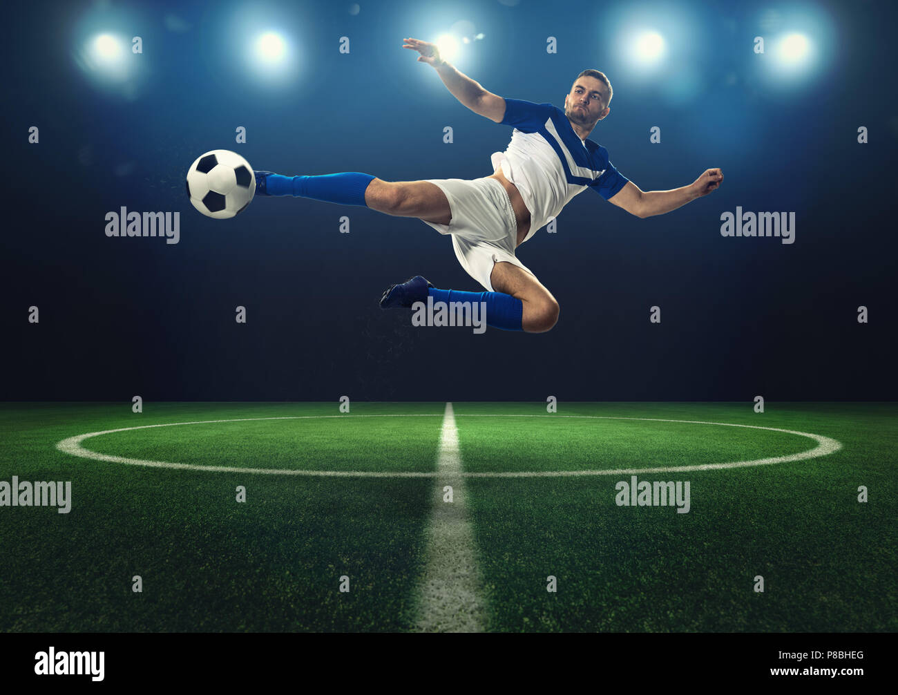 Soccer striker hits the ball with an acrobatic kick Stock Photo