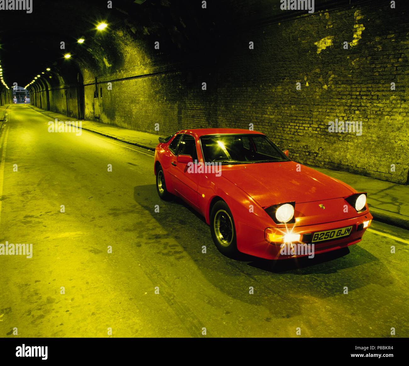 Porsche 944 1985 model year with pop up headlights lit up in an urban tunnel Stock Photo