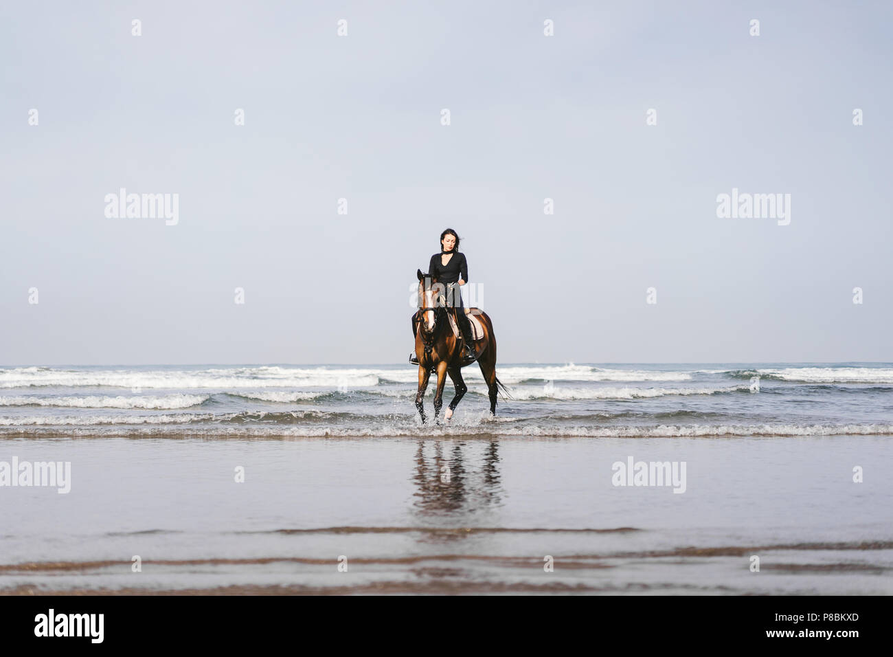 Young woman riding horse on beach hi-res stock photography and images ...