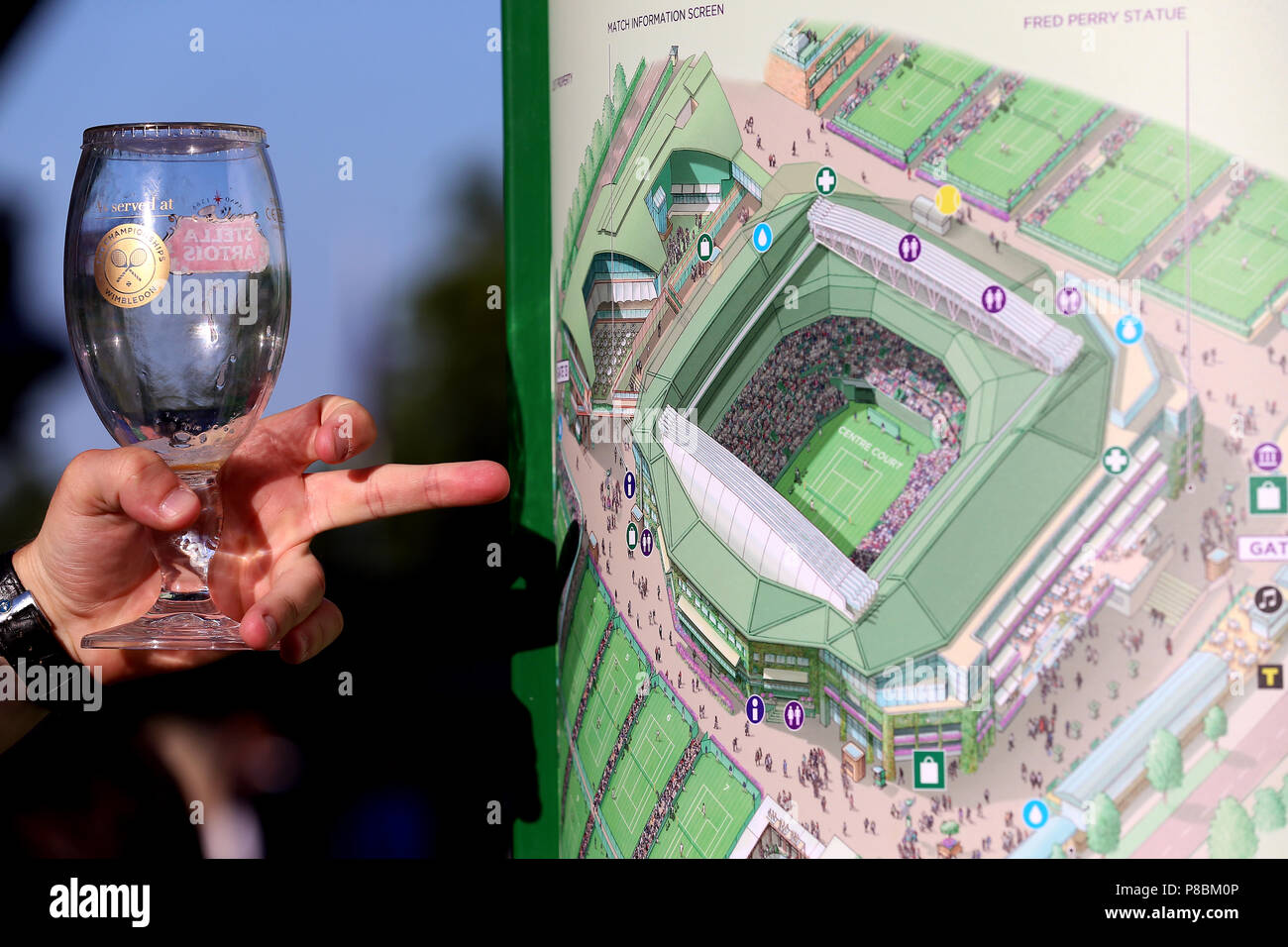 A spectator looks at a map of centre court and the surrounding area on day  eight of the Wimbledon Championships at the All England Lawn Tennis and Croquet  Club, Wimbledon Stock Photo -