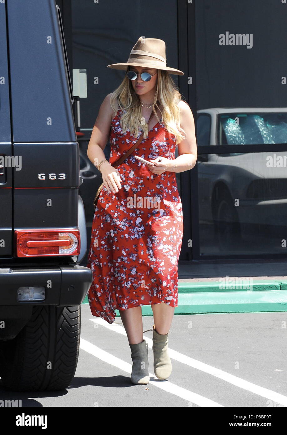Pregnant Hilary Duff conceals her baby bump in a red summer dress as(01)