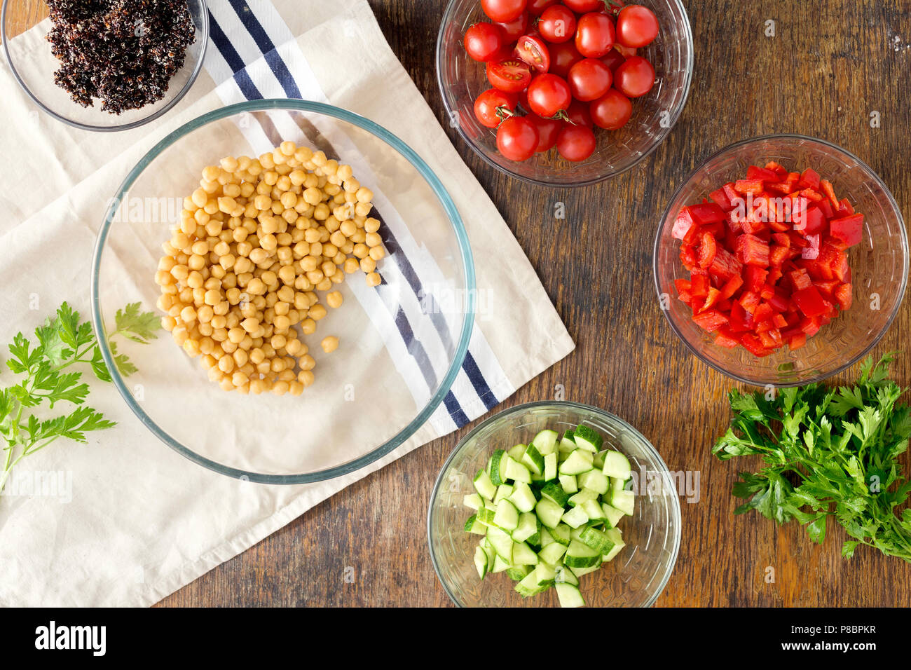 Superfood concept. Ingredients for cooking vegetarian salad with chickpeas, black quinoa and vegetables on wooden table, top view Stock Photo