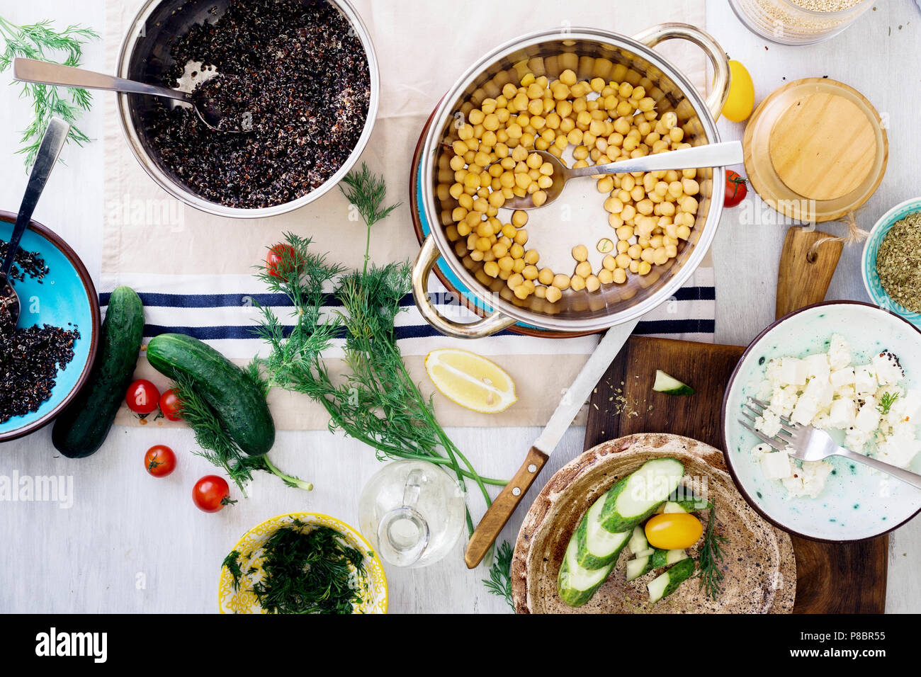 Ingredients for cooking healthy salad with black quinoa, chickpea, feta cheese and vegetables on wooden table, top view. Healthy food concept Stock Photo