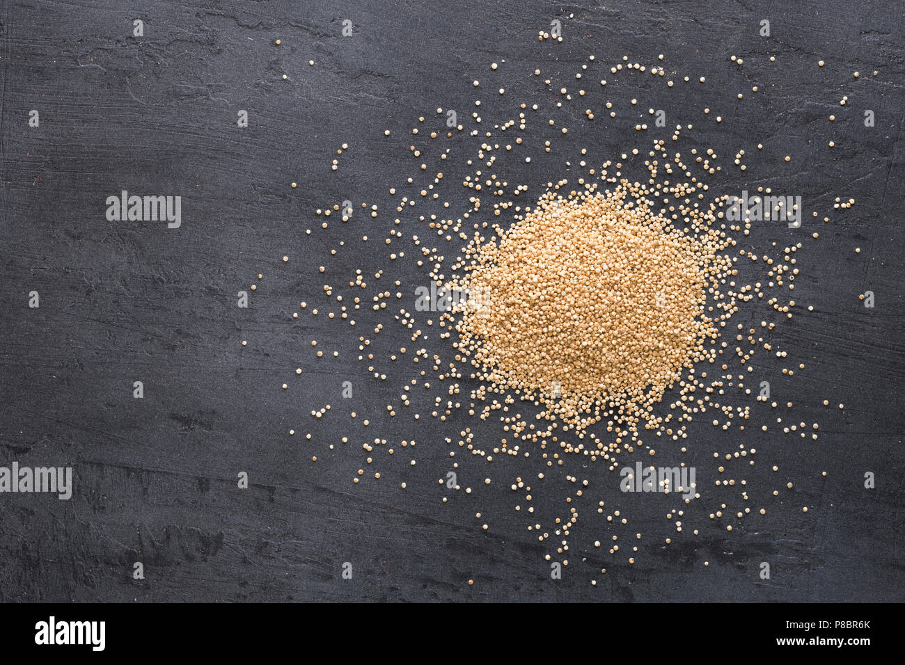 Heap of quinoa on a dark background, top view Stock Photo