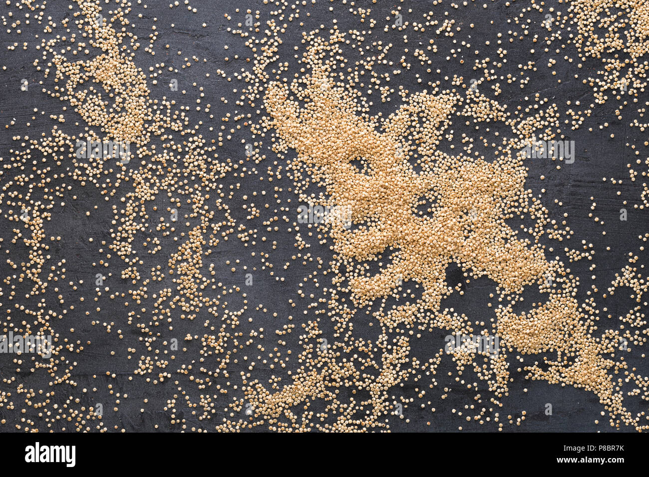 Heap of quinoa on a dark background, top view Stock Photo