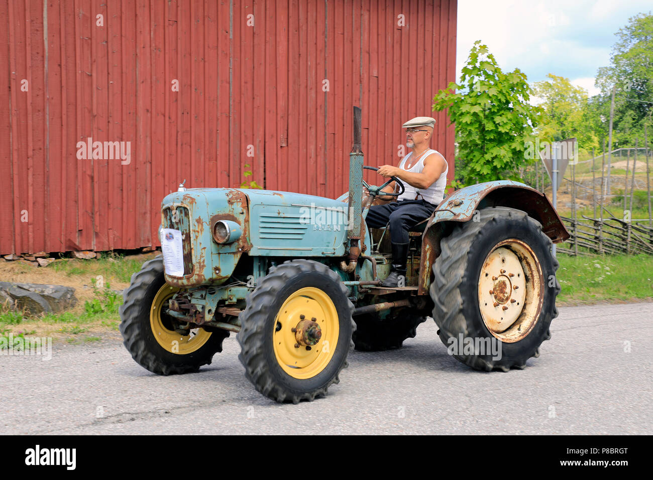 Classic MAN tractor and driver on the annual Kimito Traktorkavalkad, Tractor Cavalcade, Kimito, Finland - July 7, 2018. Stock Photo