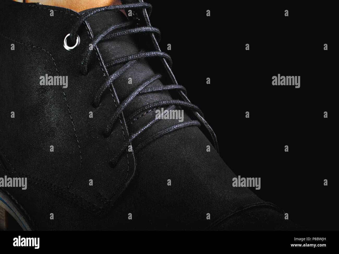 Men's black leather boots shoes laces closeup macro, black background low key Stock Photo