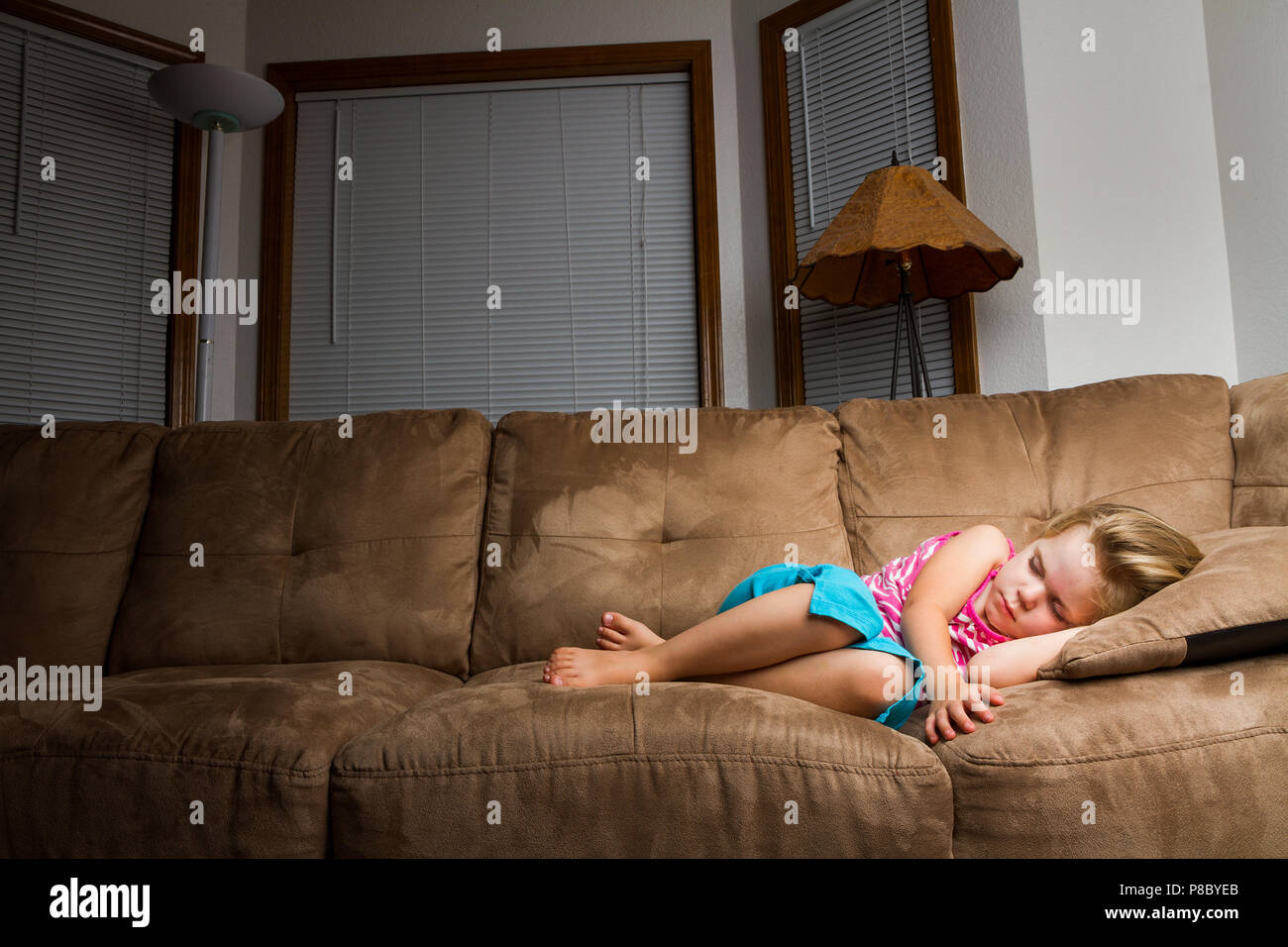 Child On Couch Curled Up Into A Little Ball Lighting Focus On