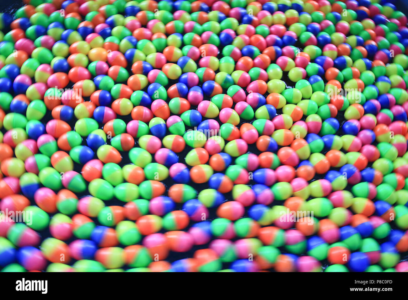 colorful plastic eggs floating on the water background Stock Photo