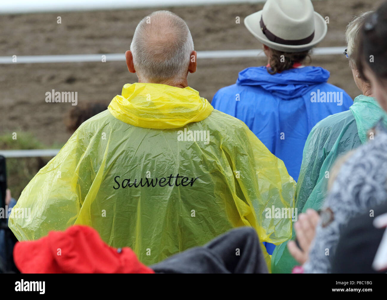 Ganschow, Germany, man wears a raincoat with the inscription Sauwetter Stock Photo