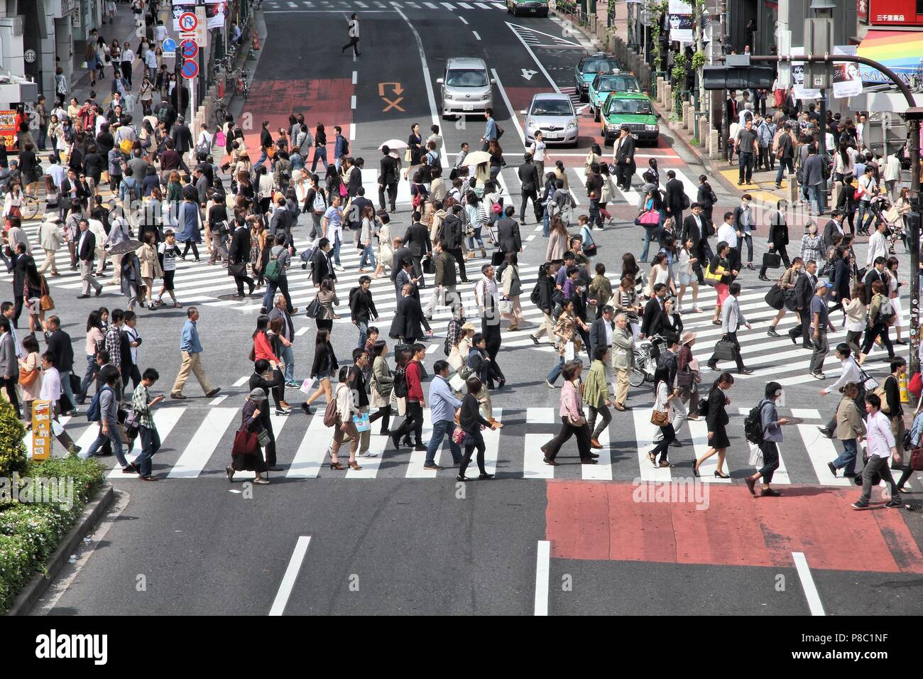 TOKYO, JAPAN - MAY 11, 2012: People walk the Hachiko crossing in Shibuya, Tokyo. Shibuya crossing is one of busiest places in Tokyo and is recognized  Stock Photo