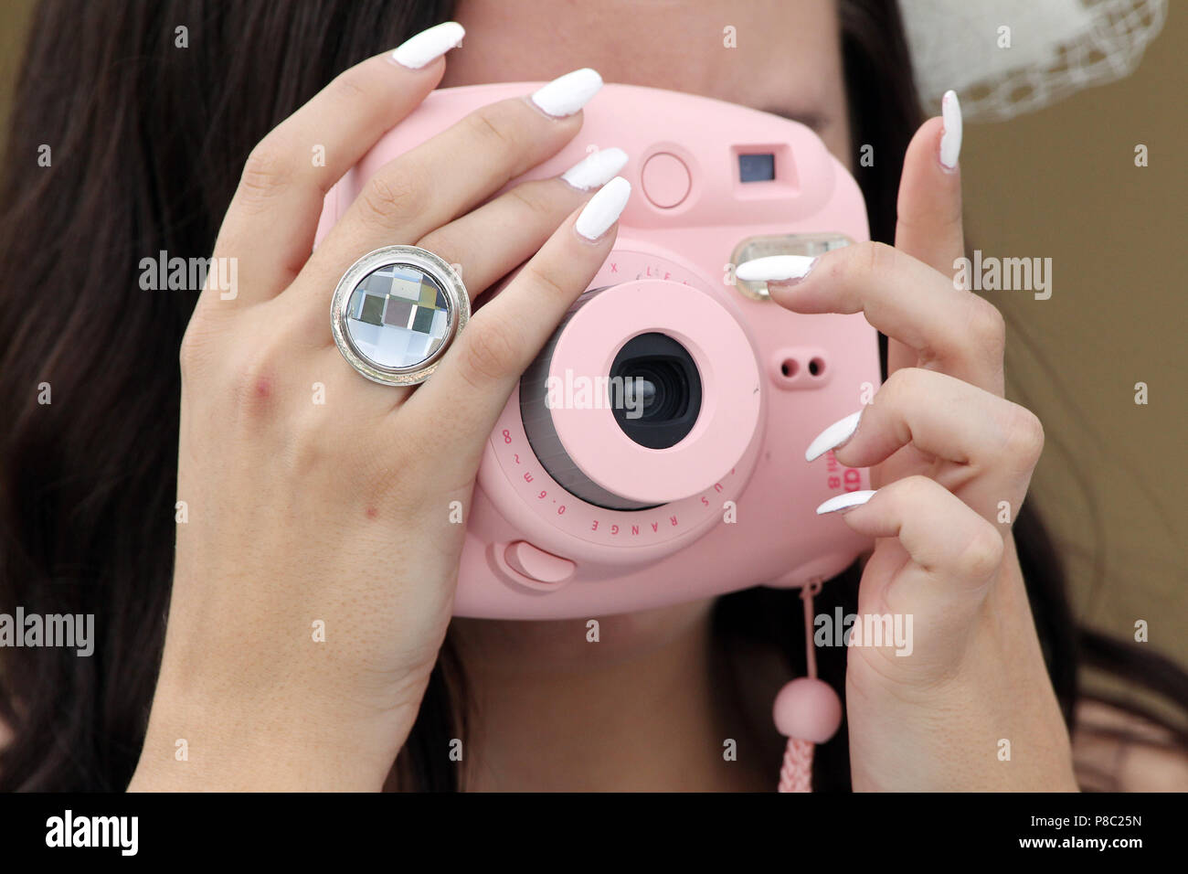 Iffezheim, Germany, close-up, woman takes a picture with a pink compact camera Stock Photo