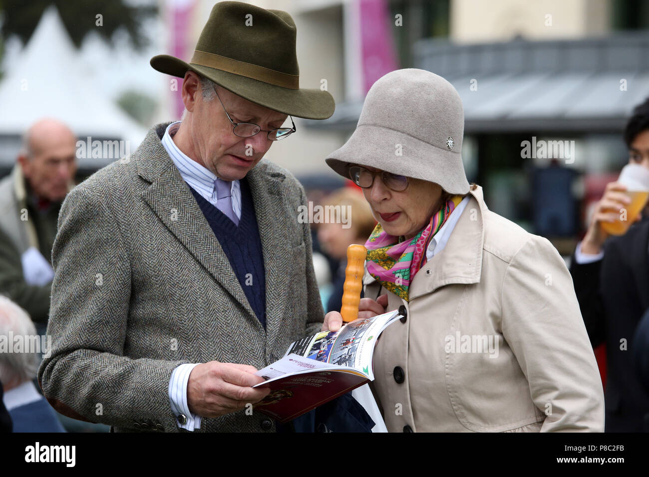 Chantilly, France, elegantly dressed couple on the racecourse looking into the race program Stock Photo