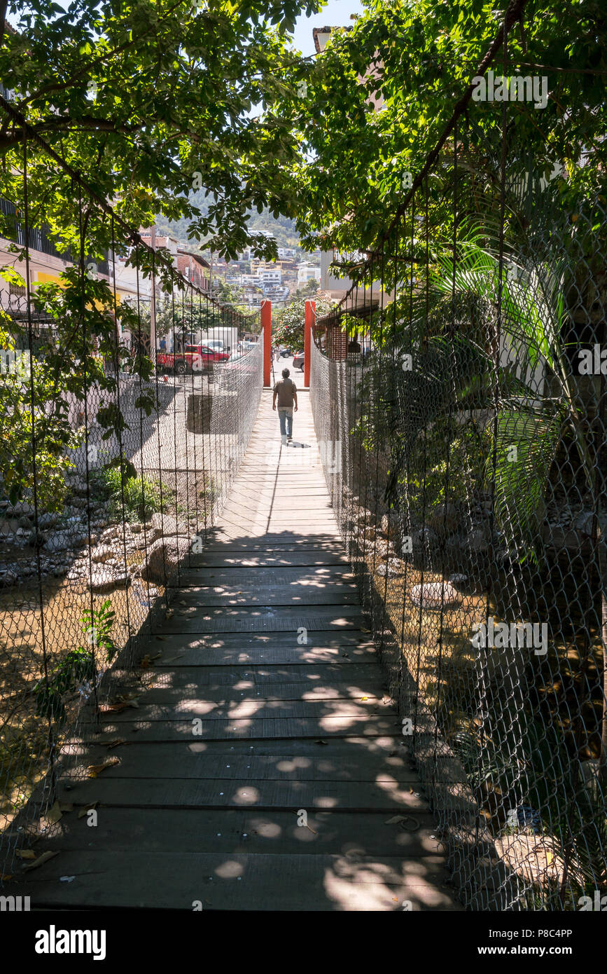 PUERTO VALLARTA, MEXICO - March 10, 2018: Walking along the suspension bridge from Isla Rio Cuale in downtown Puerto Vallarta , MX-JAL. Stock Photo