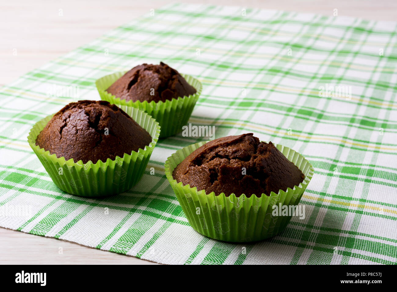 Chocolate breakfast muffins in the green wrappers on the checkered