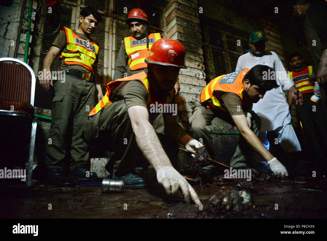 Peshawar, Pakistan. 10th July, 2018. Rescuers work at the blast site in Peshawar, northwest Pakistan, on July 10, 2018. At least 13 people were killed and dozens of others injured in a blast that hit a public gathering of a political party in Pakistan's northwest provincial capital of Peshawar on Tuesday night, local media reported. Credit: Umar Qayyum/Xinhua/Alamy Live News Stock Photo