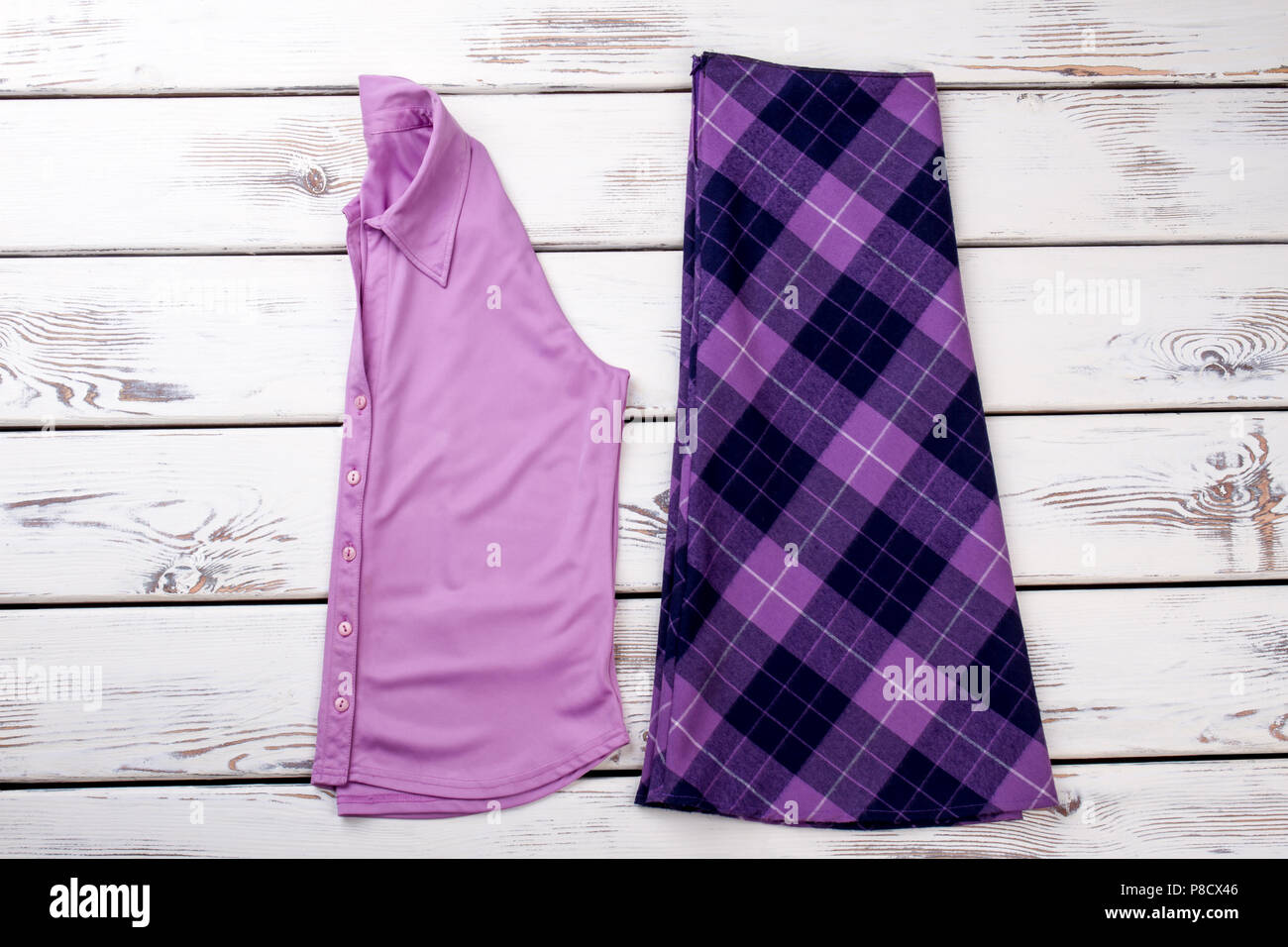Pink folded shirt and purple checkered skirt. Stock Photo