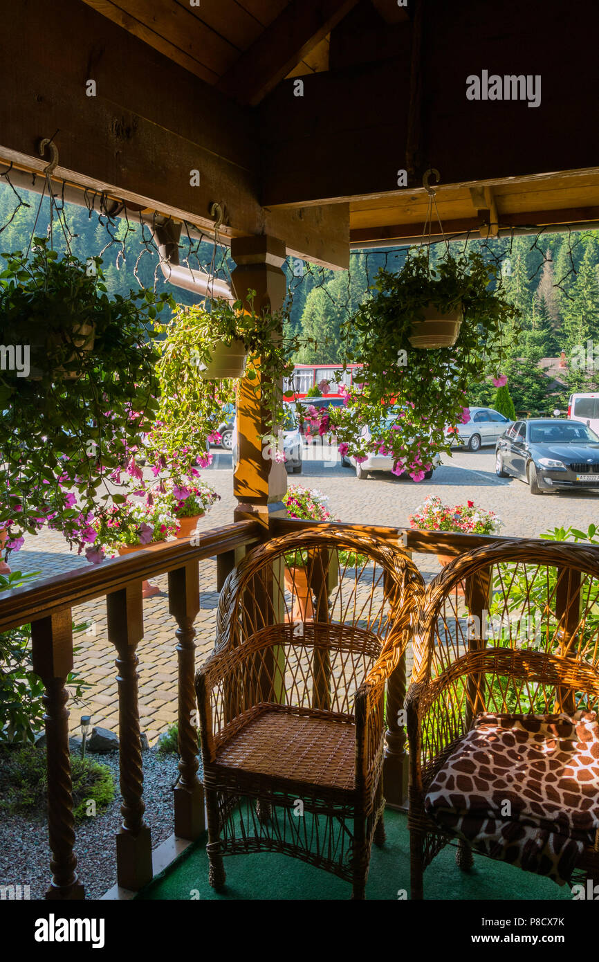 Comfortable Wooden Veranda With Wicker Chairs On The Background Of