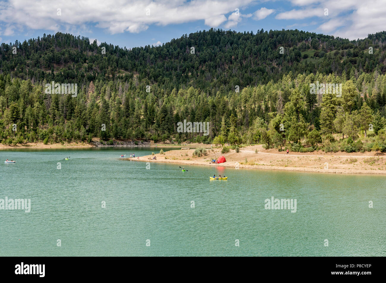 People fishing, kayaking and canoeing surrounded by pine trees at Grindstone Lake in the New Mexico mountains near Ruidoso, USA. Stock Photo