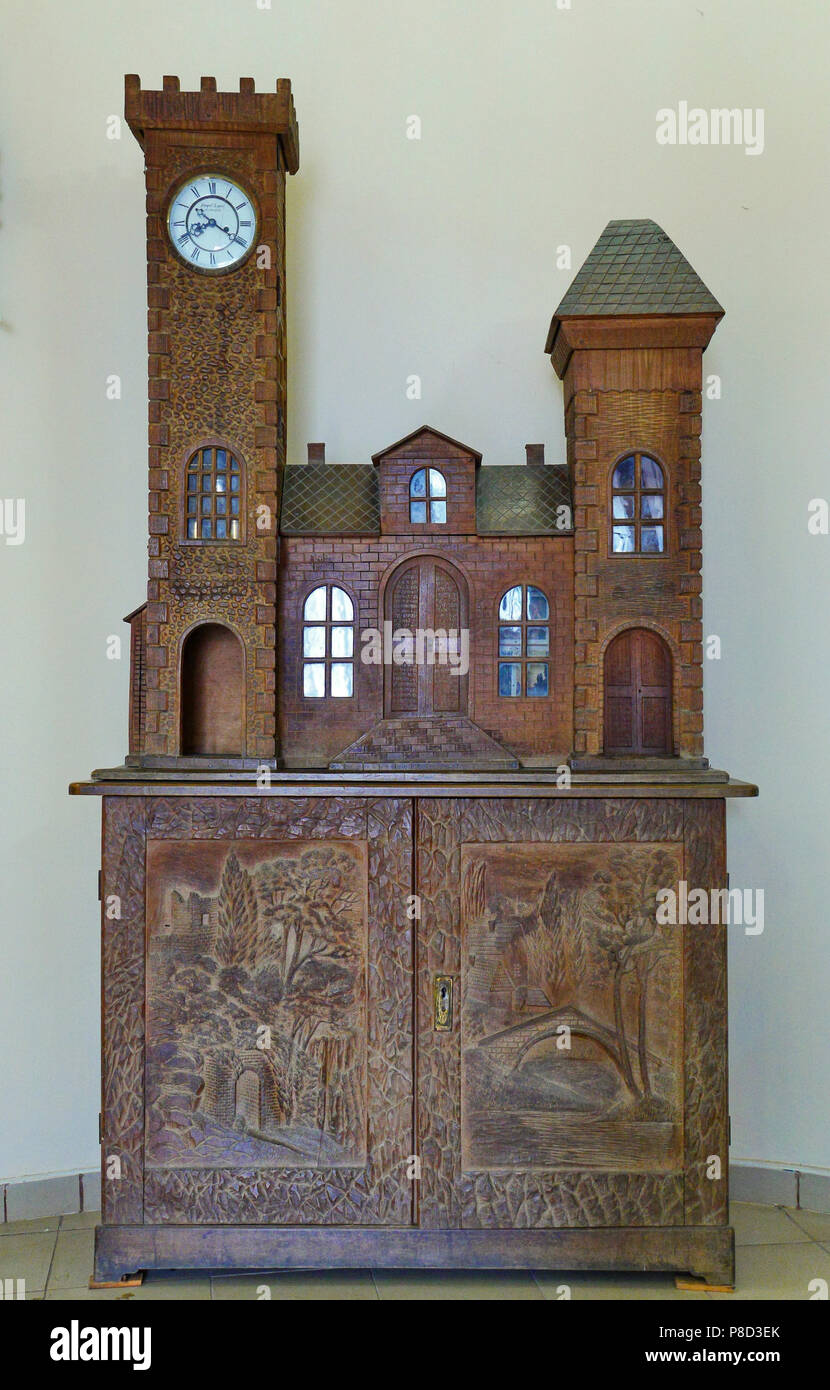 Carved wooden hand-made cabinet made of wood. With beautiful turrets with glasses and clocks. And the pictures on the doors are carved directly on the Stock Photo