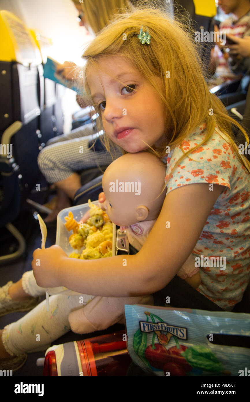 A young girl of 2 and a half eating a packed meal of pasta on budget airline Ryanair Stock Photo