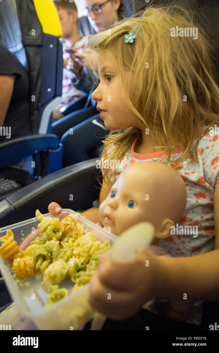 A young girl of 2 and a half eating a packed meal of pasta on budget airline Ryanair Stock Photo