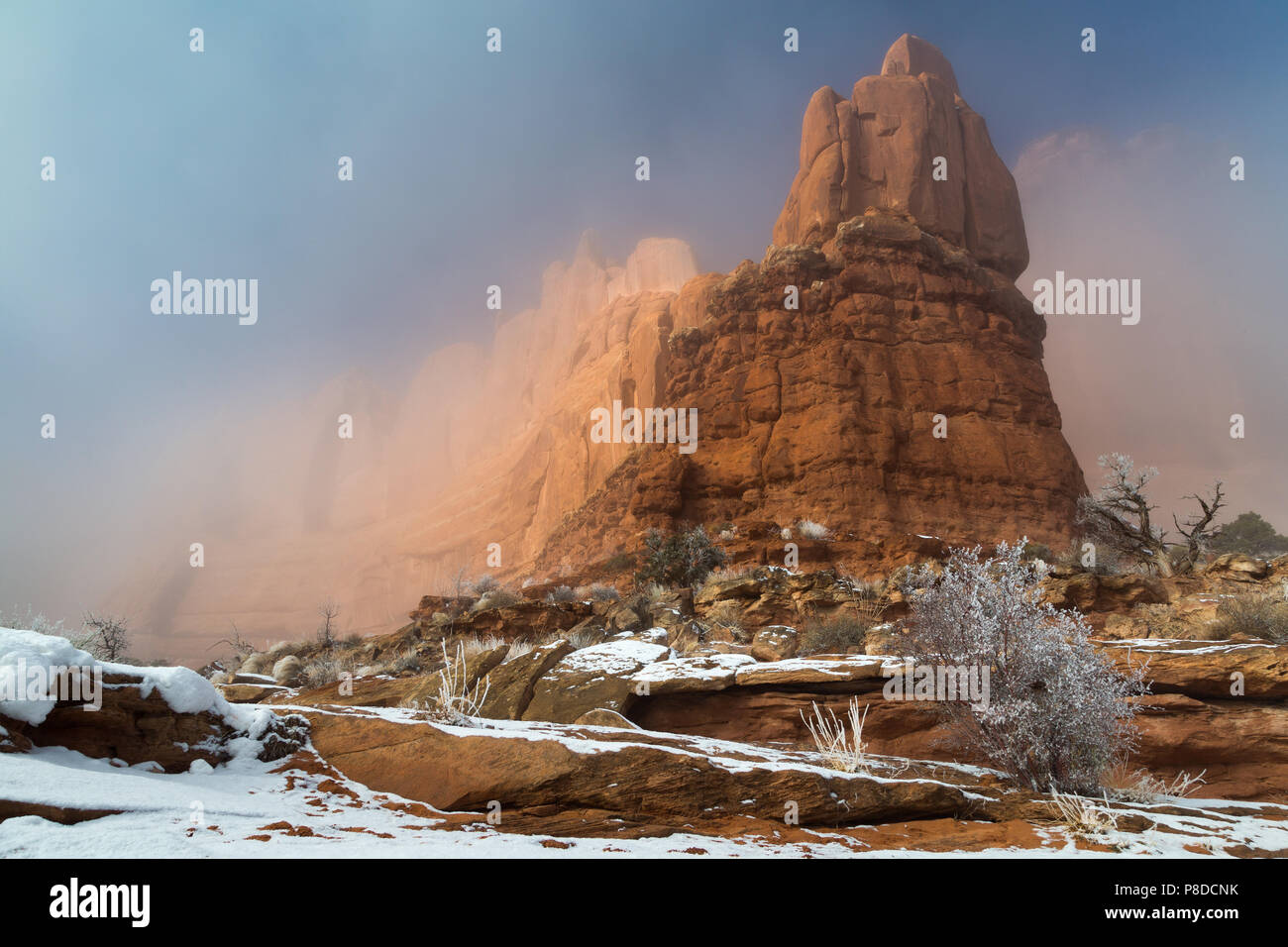 A thick winter fog surrounding and engulfing the sandstone buttes along the Park Avenue Trail. Arches National Park, Utah Stock Photo