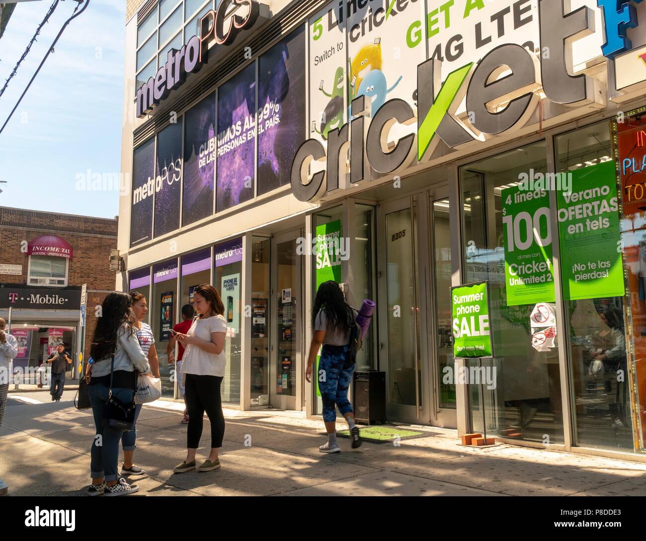 MetroPCS and Cricket wireless stores next to each other on Roosevelt Avenue in the Jackson Heights neighborhood in Queens in New York on Sunday, July 8, 2018. The Jackson Heights neighborhood is home to a mosaic of ethnic groups  which include Hispanics, Indians, Pakistanis, Tibetans, Southeast Asian as well as long-time Jewish and Italian residents.  (Â© Richard B. Levine) Stock Photo