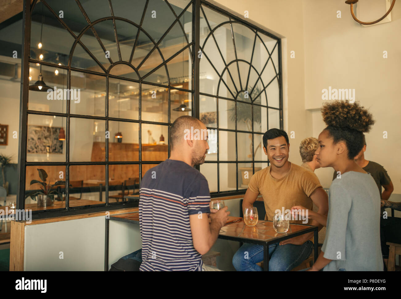 Diverse young friends enjoying drinks together in a bar Stock Photo